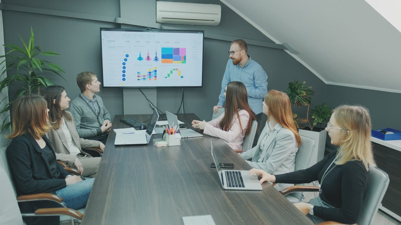 A team leader facilitating a working session with colleagues around a table